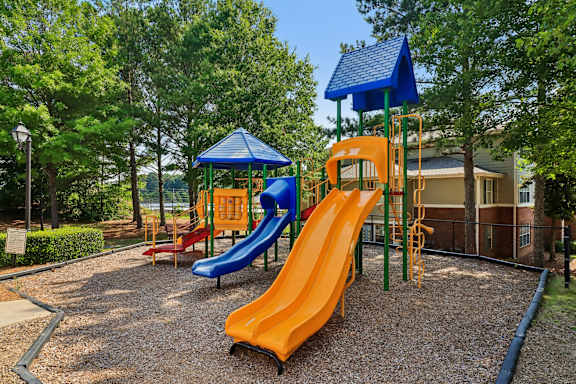 A playground with a blue and orange slide.