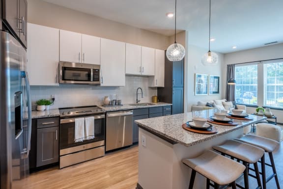 a kitchen with white cabinets and stainless steel appliances at The Livano Tryon, Charlotte, NC, 28213