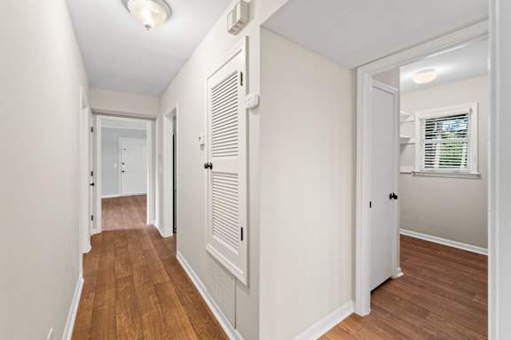A hallway with white walls and wood floors. at Villas on Briarcliff, Georgia