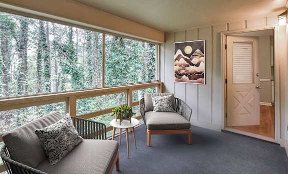 Screened in patio with grey chairs and artwork at Villas on Briarcliff, Atlanta, 30329