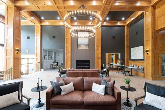 A large, open-concept living room with a fireplace and a chandelier.