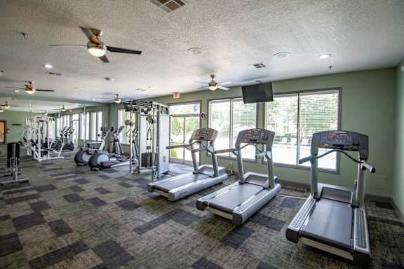 A gym with treadmills, weights, and exercise equipment.