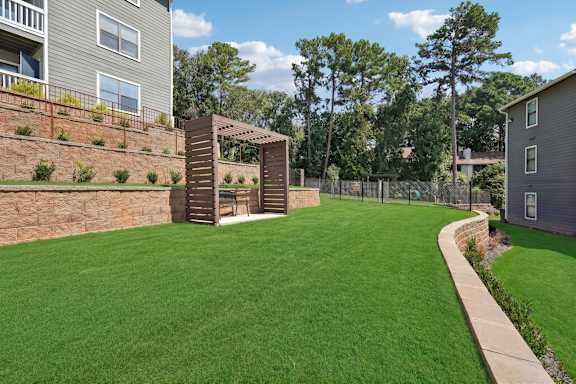 A backyard with a green lawn and a wooden structure.