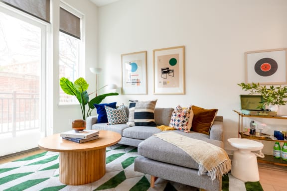 a living room with a gray couch and a round coffee table