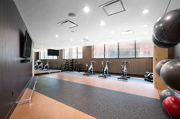 a gym with weights and a tv on the wall