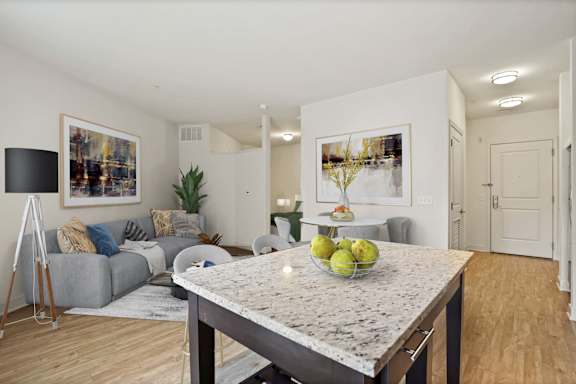 A kitchen with a marble countertop and a bowl of fruit on it.