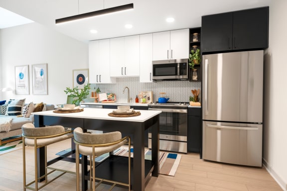 a kitchen and dining room with stainless steel appliances and a table and chairs