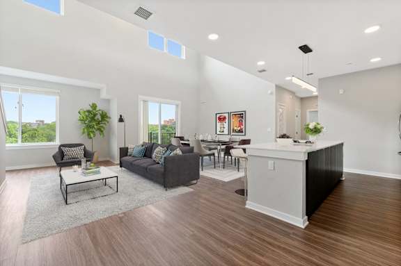 A living room with a grey couch, a white coffee table, and a large window.