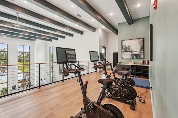 A room with exercise equipment and a balcony with a view.