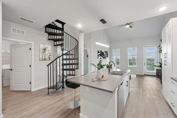 Staged A3 floor plan showing kitchen, spiral staircase, and open living room concept at The Crossing at Palm Aire