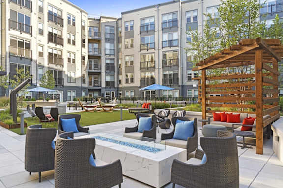 A patio with a table and chairs is surrounded by apartment buildings.