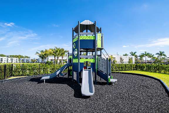 A playground with a blue slide and a white slide.