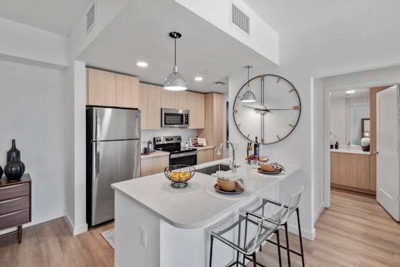 A modern kitchen with a large island and stainless steel appliances.