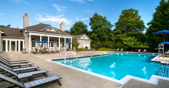 a swimming pool in front of a house with a resort style pool