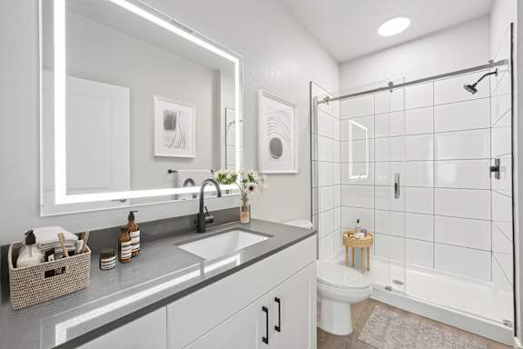 A modern bathroom with a white toilet and a walk-in shower.