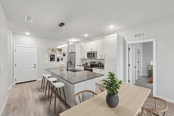 A kitchen with a dining table and chairs.