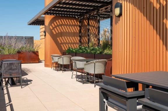a patio with tables and chairs and a wood fence