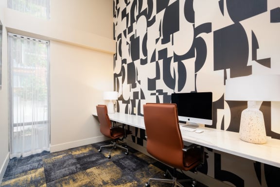 a room with two desks and two chairs and a window
