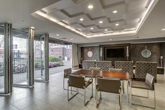 A modern dining room with a glass door leading to a balcony.