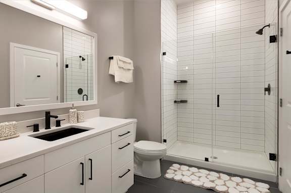 a white bathroom with a shower sink and toilet