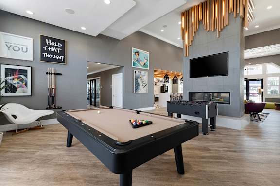 A pool table in a room with a sign that says "Hold that thought.".