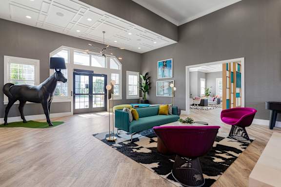 A room with a horse statue and a green couch.