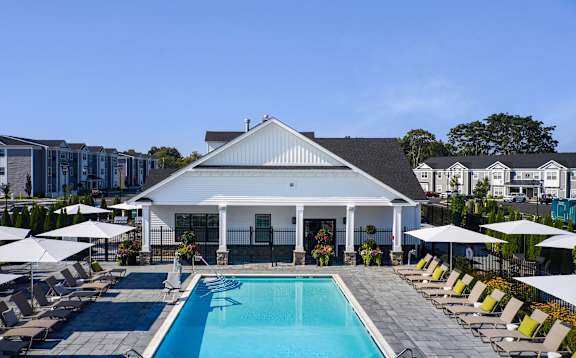 A white house with a pool in front.