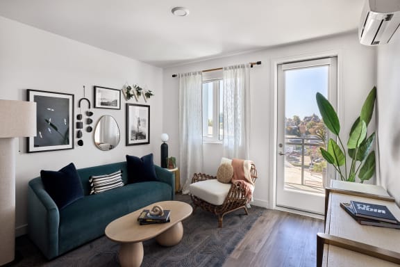 a living room with a green couch and a window