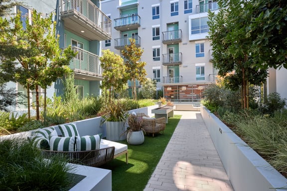 a courtyard with furniture and plants in an apartment building