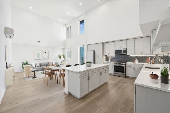 an open kitchen and living room with a table and chairs