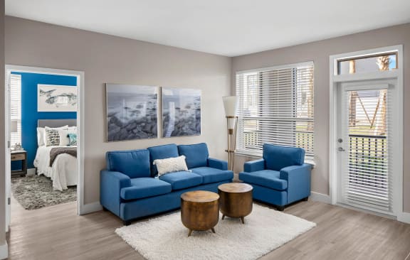 a living room with a blue couch and two blue chairs