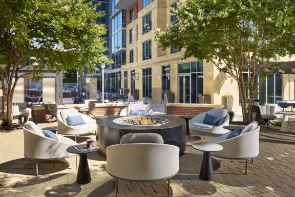 a patio with chairs and tables and a fire pit