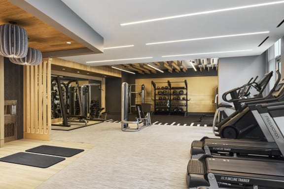 a gym with cardio machines and weights on the floor