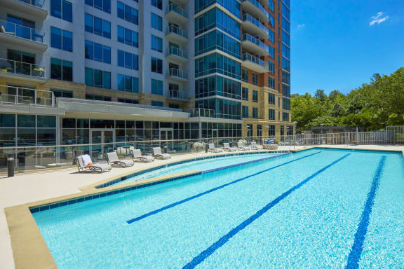 a swimming pool with an apartment building in the background