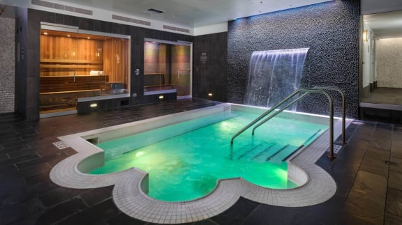 a swimming pool with a waterfall and a jacuzzi