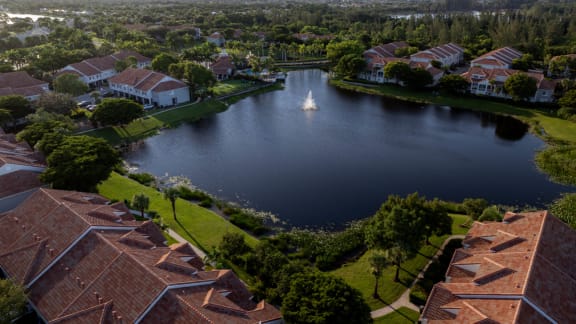 an aerial view of a lake with a sailboat in the middle of it