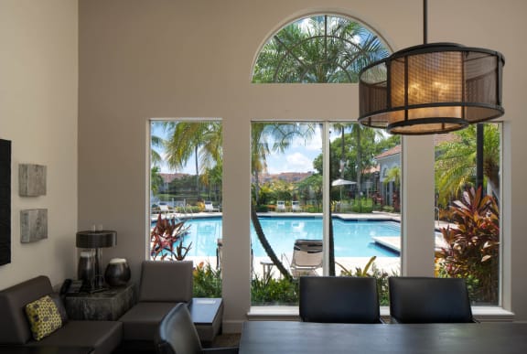 a living room with a large window overlooking a swimming pool