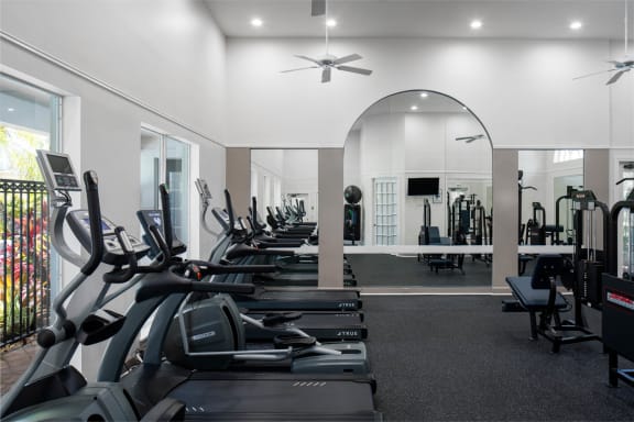 a gym with rows of treadmills and other exercise equipment