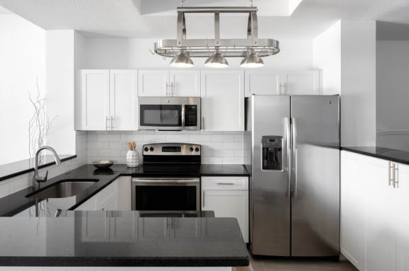 a kitchen with stainless steel appliances and white cabinets