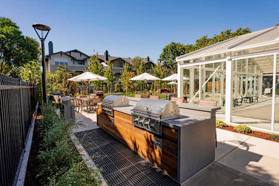A modern outdoor kitchen area with a grill and seating area.