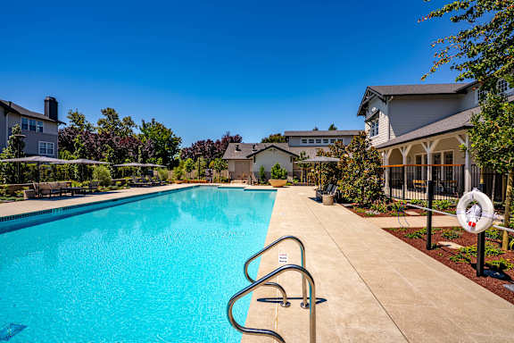 A swimming pool with a diving board and a lifeguard stand.