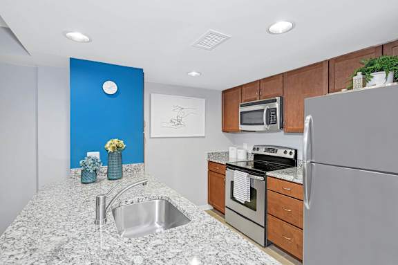 A kitchen with a granite countertop and stainless steel appliances.