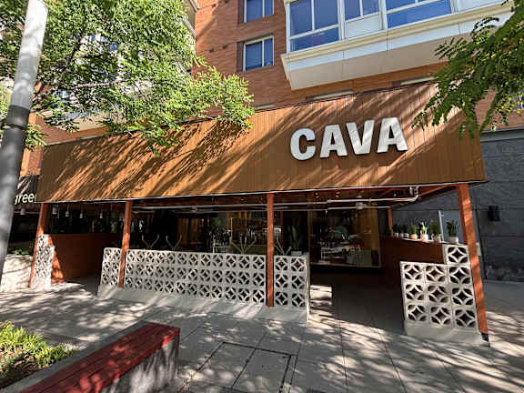 A building with a brown awning and the word "CAVA" on it.