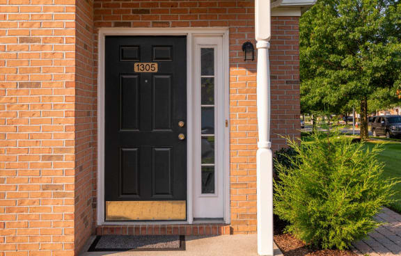a black door on the side of a brick building