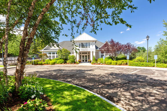 the front of a house with a driveway and trees