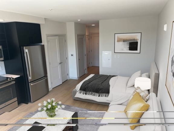 a studio apartment with a bed and a refrigerator
