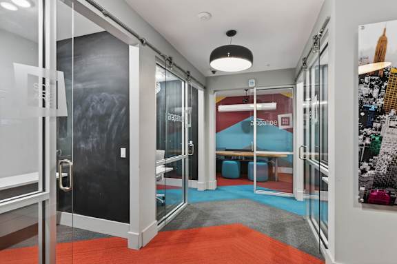 A room with a red carpet and glass walls.
