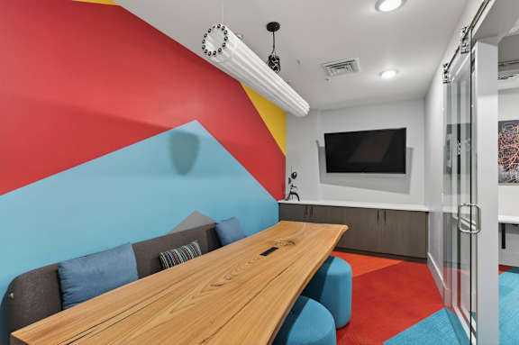 A modern dining area with a wooden table and blue chairs.