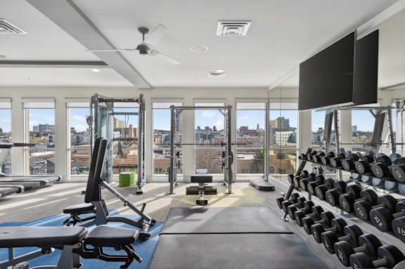 Bright apartment gym with exercise machines and sleek modern interior.