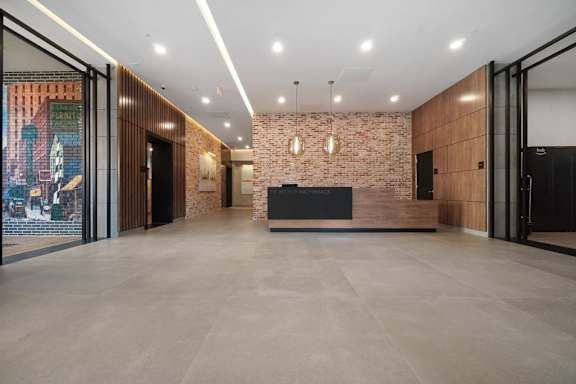 A reception area with a brick wall and a black counter.